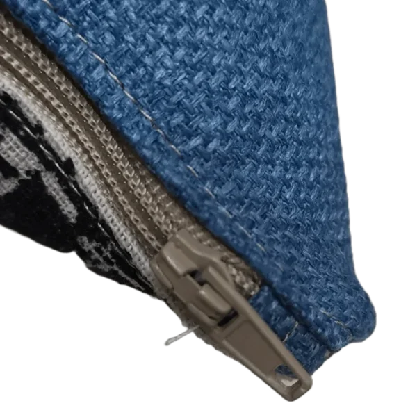 Close-up of blue fabric with zipper partly open.