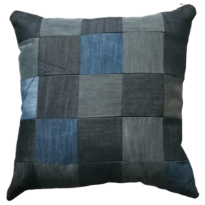 Patchwork denim cushion on white background.