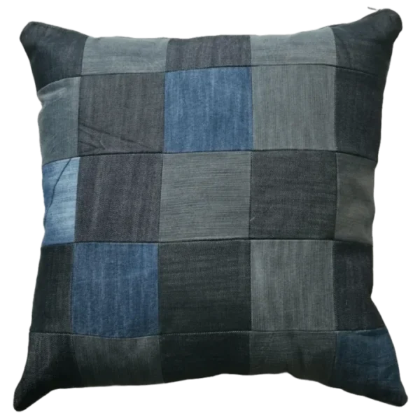 Patchwork denim cushion on white background.