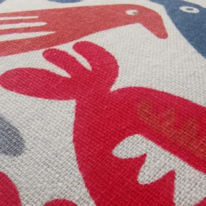 Close-up of red and white fabric with stylised design.