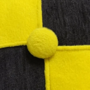 Yellow pom-pom on contrasting fabric textures.
